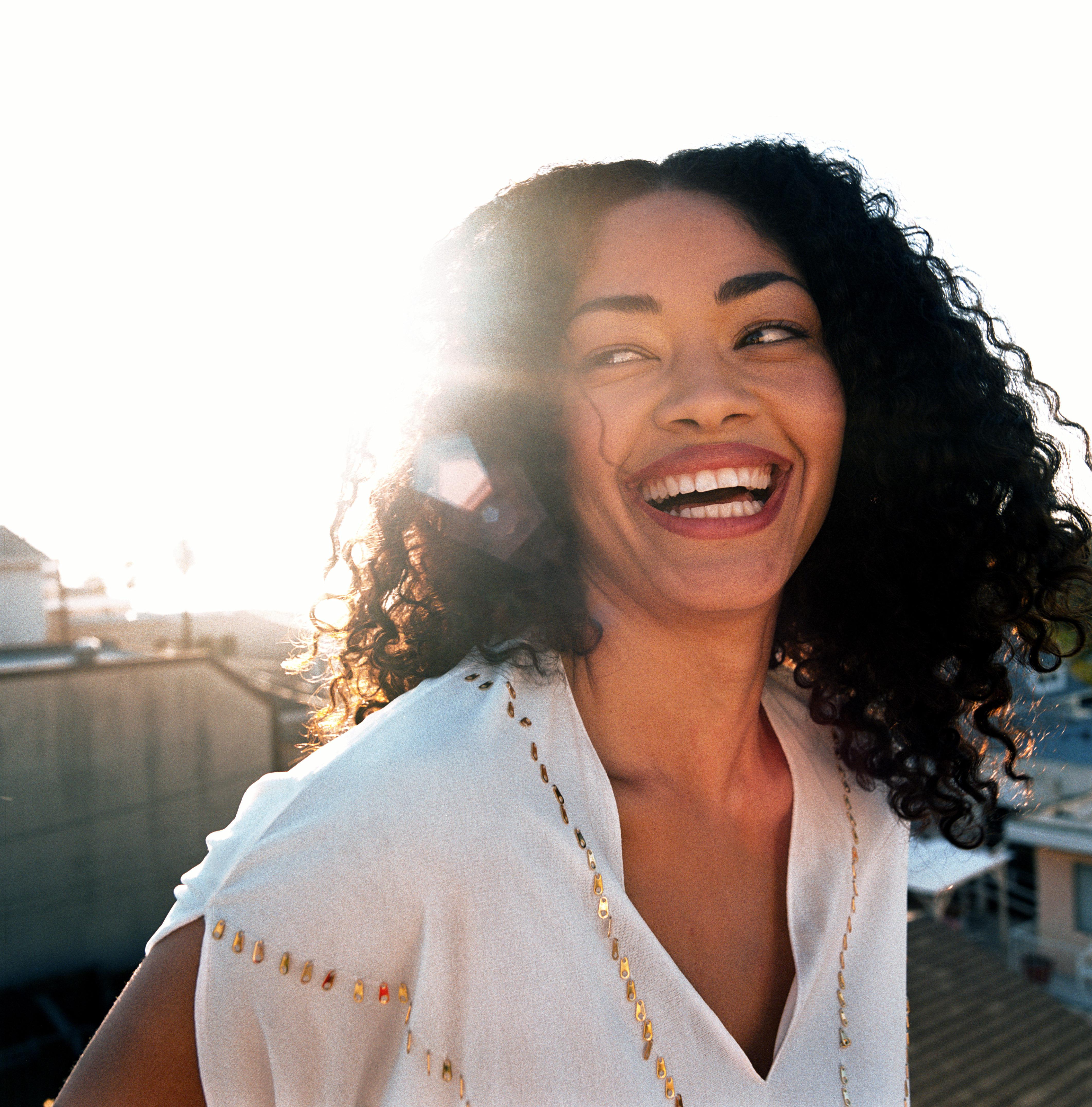 Young woman wearing white top, laughing