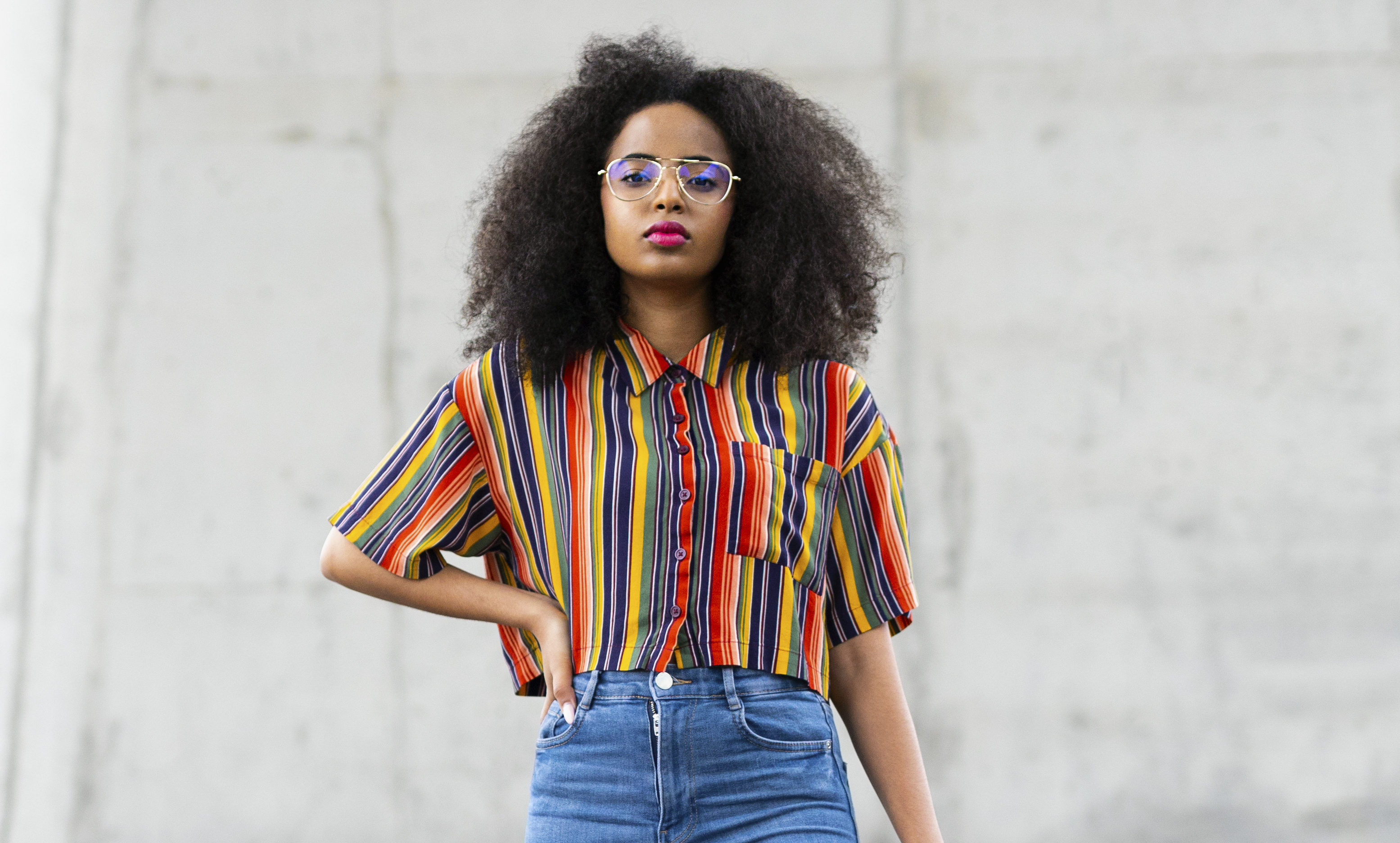 Portrait of confident, cool young woman standing under overpass