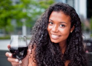 Happy Young Woman Enjoying glass of red wine - stock photo