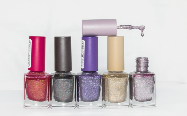Close-Up Of Nail Polish Bottles Against Gray Background