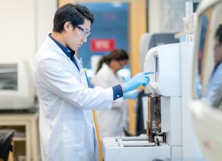 Asian Scientist Setting Medical Testing Equipment stock photo
