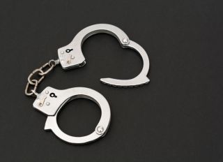 High Angle View Of Handcuffs Over Black Background