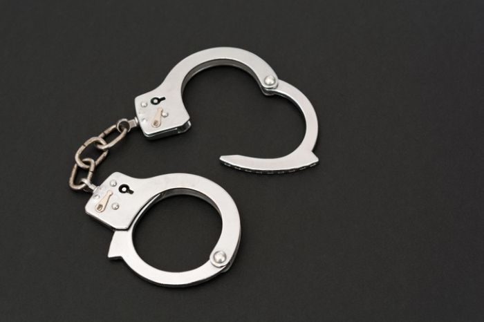 High Angle View Of Handcuffs Over Black Background