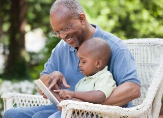 Black grandfather and grandson using digital tablet - stock photo