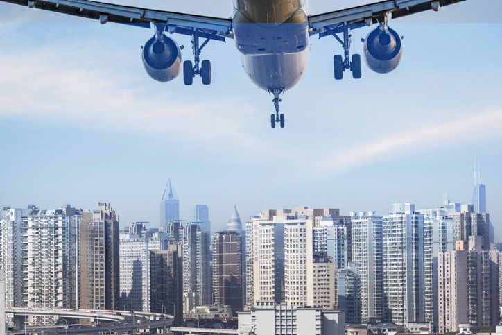 One airplane approaching the modern shanghai city