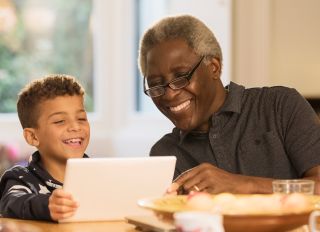 Smiling grandfather and grandson using digital tablet - stock photo