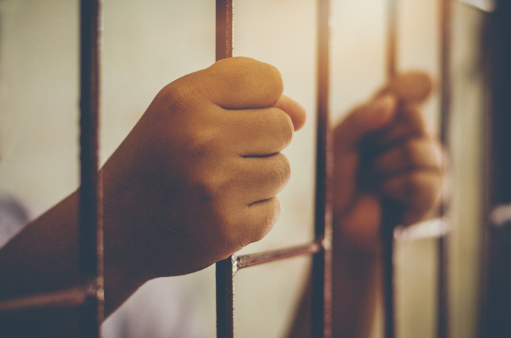 Cropped Hands Of Prisoner In Jail