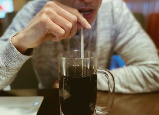 Man Sips Beverage in Restaurant