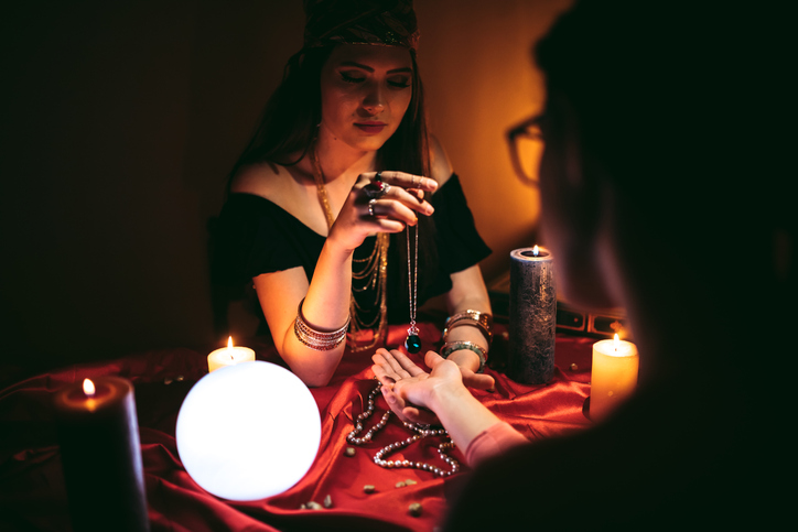 Fortune teller reading from palm