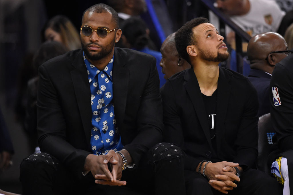 Golden State Warriors' DeMarcus Cousins (0) and Golden State Warriors' Stephen Curry (30) sit on the bench while playing the Brooklyn Nets during the second quarter of their NBA game at the Oracle Arena in Oakland, Calif. on Saturday, Nov. 10, 2018. (Jose