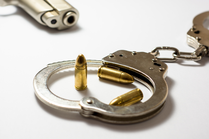 High Angle View Of Bullets And Handcuffs With Gun On White Background