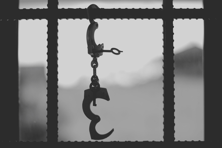 Silhouette Handcuffs Hanging On Railing