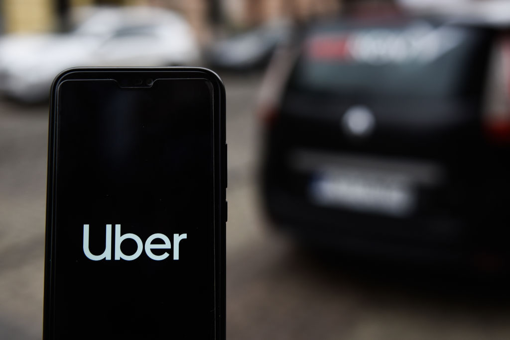 In this photo illustration an Uber logo seen displayed on a...
