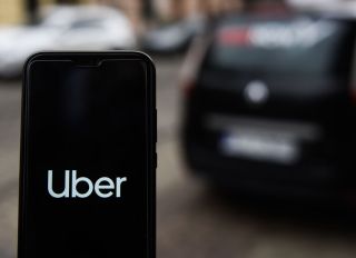 In this photo illustration an Uber logo seen displayed on a...