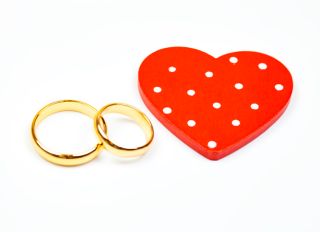 Close-Up Of Wedding Rings and red heart
