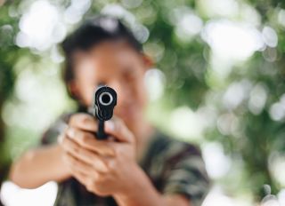 Close-Up Of Handgun Holding By Person Outdoors