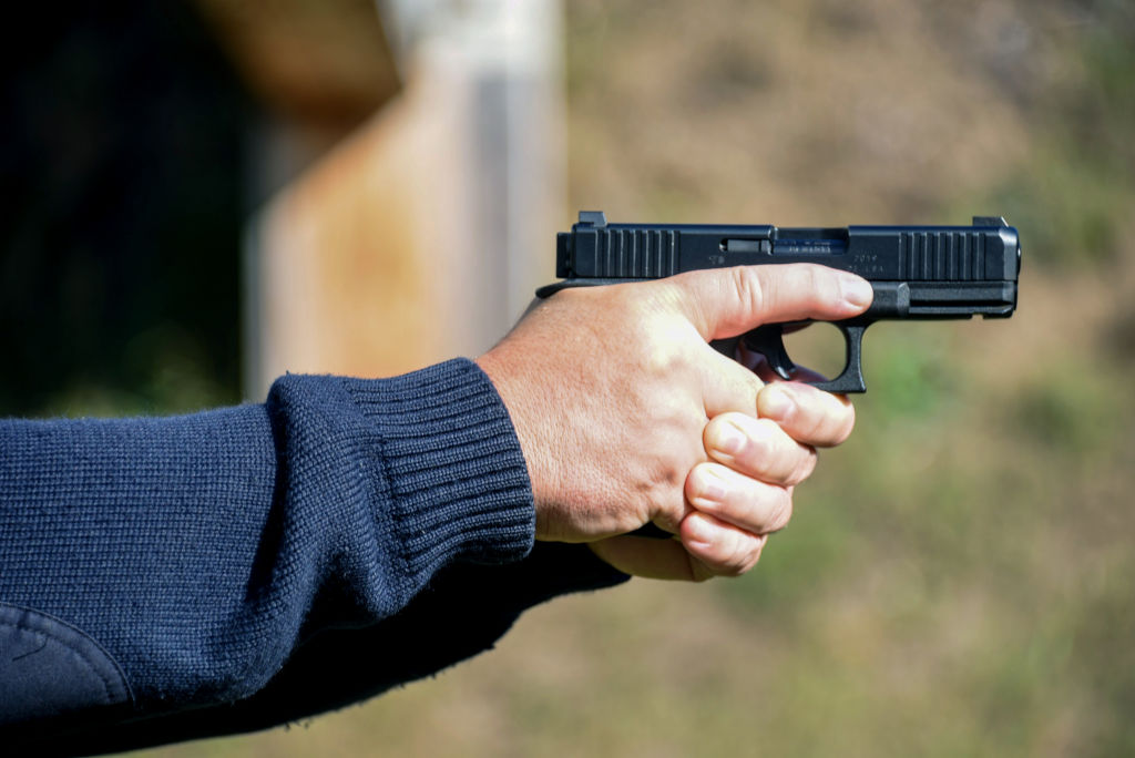 Policeman points a pistol at a shooting range