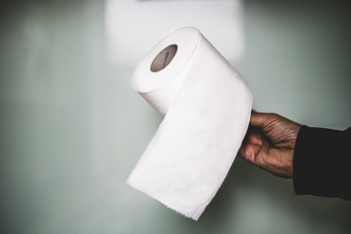 A man holding a roll of toilet paper