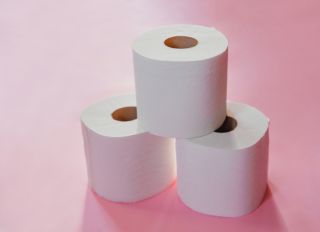 Small stack of toilet paper on pink background