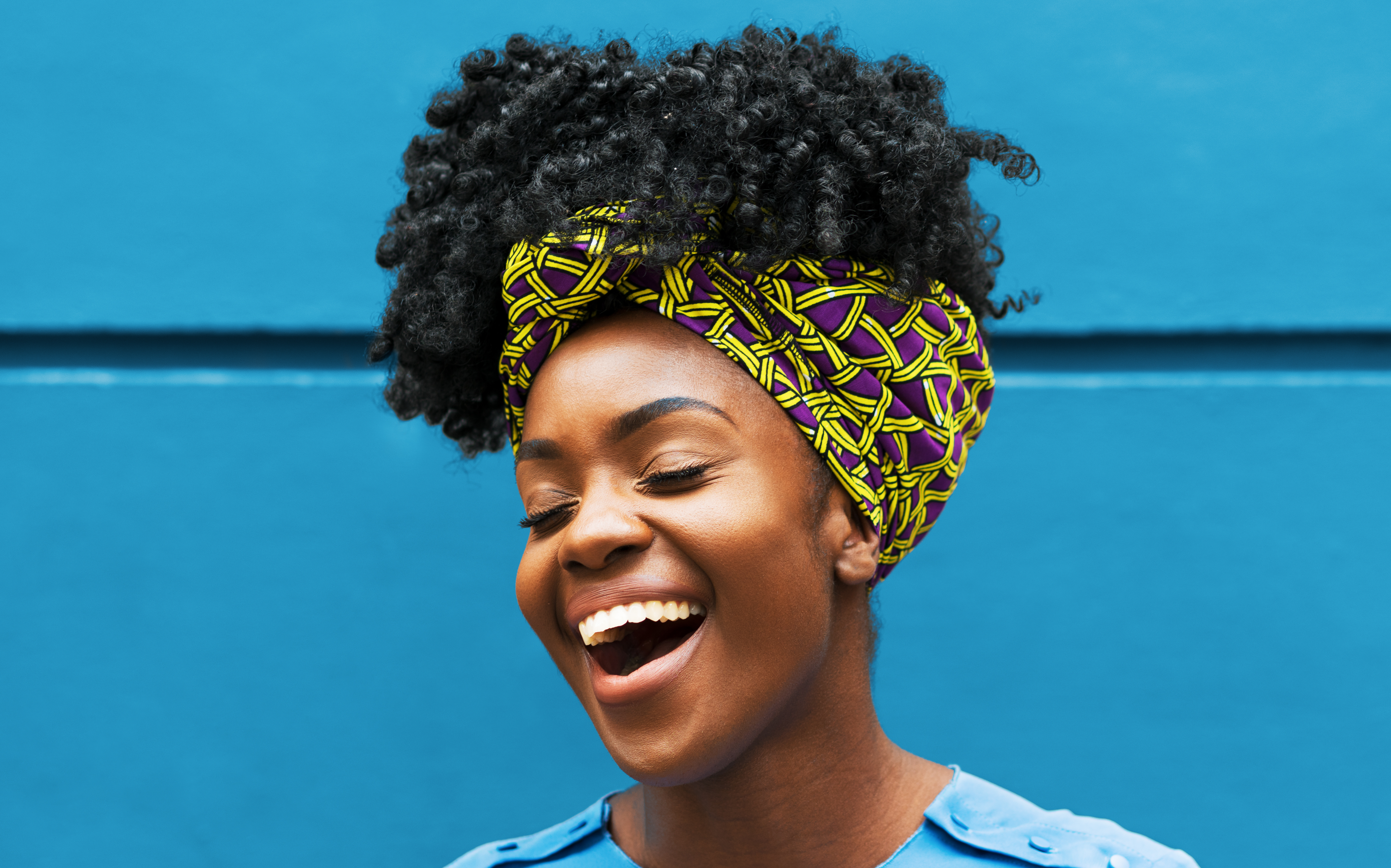 Joyous woman infront of wall - stock photo