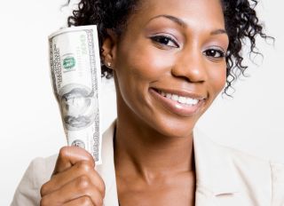 African American woman holding hundred dollar bill - stock photo