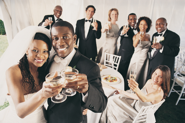 Group of People Toast a Bride and Groom at a Wedding reception in a Marquee