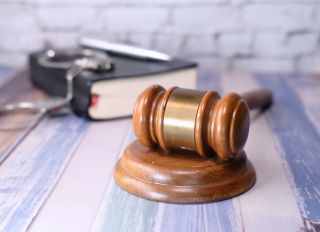 Close Up Of Gavel, Book And Handcuff On Table .