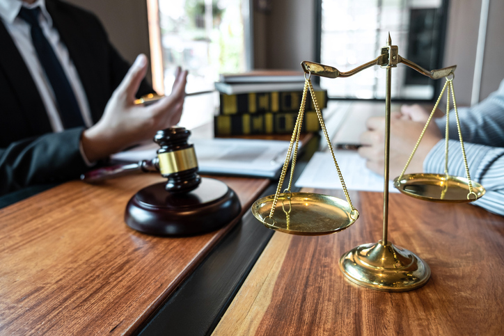 Midsection Of Judge And Client Having Discussion In Courtroom