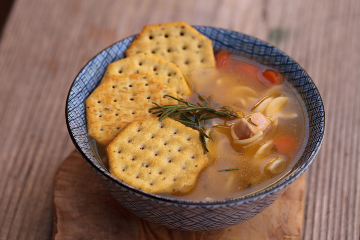High Angle View Of Soup With Crackers On Wooden Table