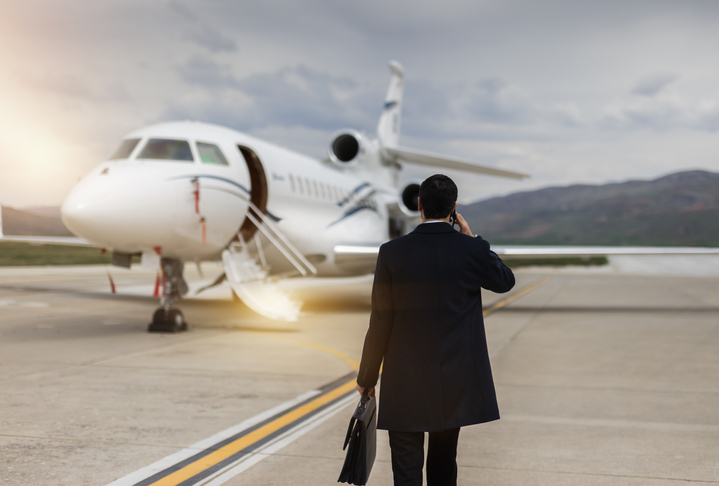 Rear View Of Businessman Walking Towards private airplane