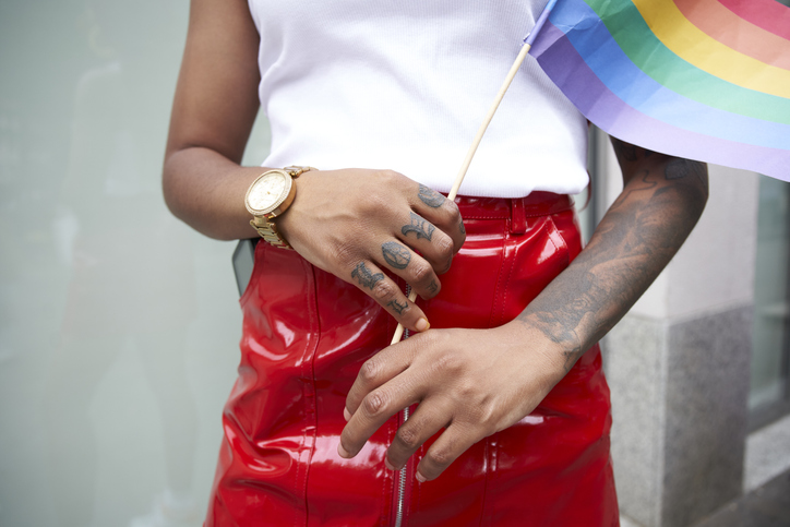 Close up of woman holding rainbow flag