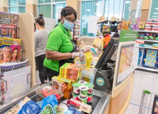Miami Beach, Publix grocery store, cashier wearing face mask, gloves and new plexiglass shield protection
