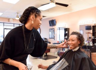 Female hairdresser checking clients hair