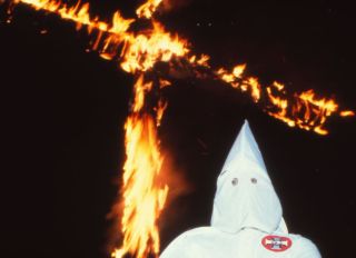 Ku Klux Klansman and a burning cross in Scotland, Connecticut in 1980
