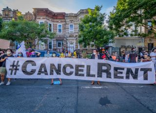 Participants hold a #CancelRent banner at the protest.