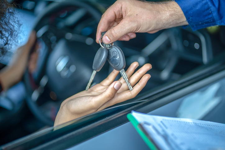Woman Receiving A Car Keys in the Auto Repair Shop