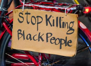 A 'Stop Killing Black People' placard seen on a bike during...