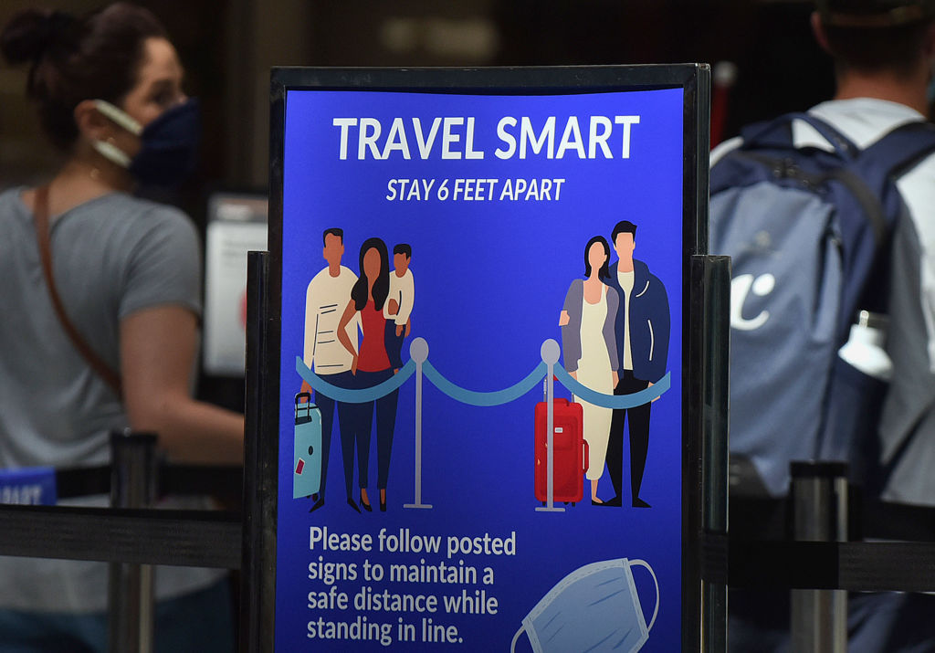 A sign reminding passengers to stay 6 feet apart is seen at...
