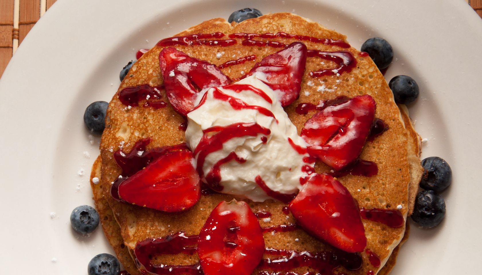 Pancakes with berries. A short stack of pancakes sits on a...