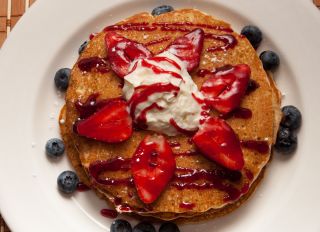 Pancakes with berries. A short stack of pancakes sits on a...