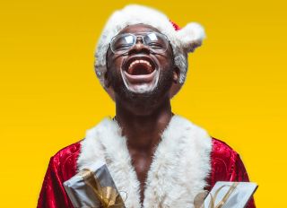 Excited black man in Santa Claus costume - stock photo