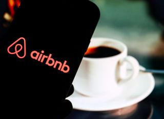 In this photo illustration a Airbnb company logo seen...