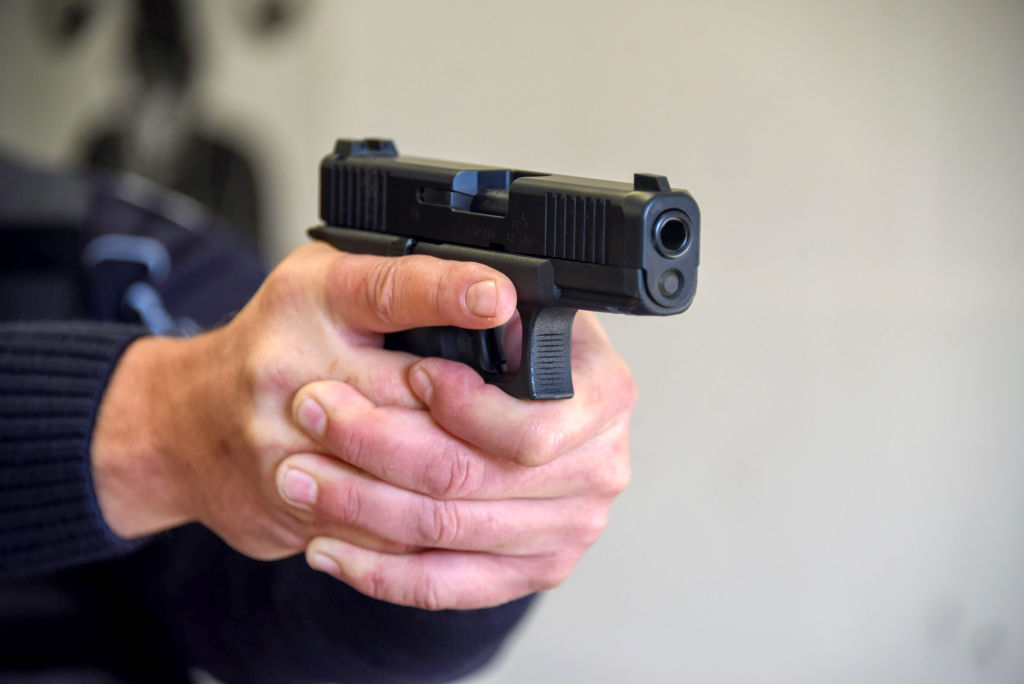 Policeman points a pistol at a shooting range