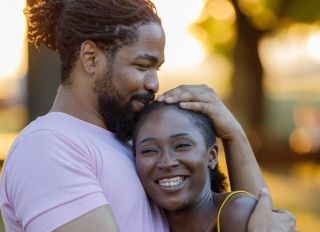 Cheerful African-American Couple is Sharing the Love in Public Park.