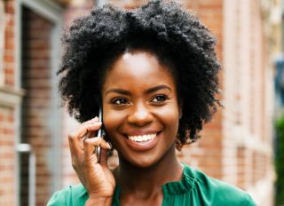 Woman on smart phone, smiling - stock photo