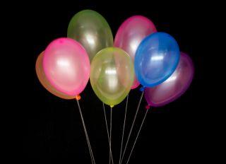 Multi Colored Balloons Tied With White Thread On Black Background