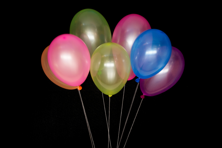 Multi Colored Balloons Tied With White Thread On Black Background