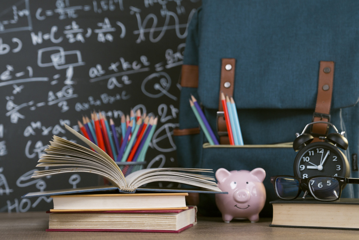 Back to school: multicolored school supplies shot on wooden desk
