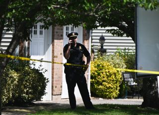 Suffolk County, New York policeman stands in front of crime scene on Long Island