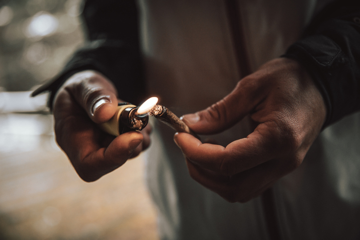 Close-up of man lighting cigarette with lighter